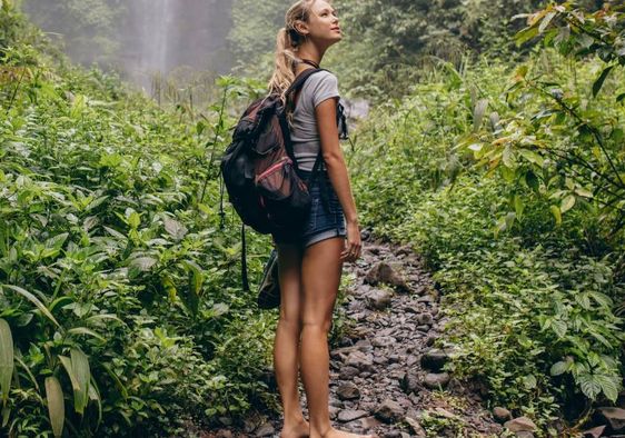A woman walking barefoot in the forest.