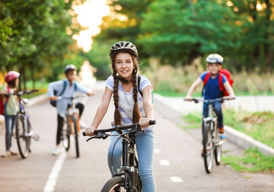 A group of children ride their bicycles.