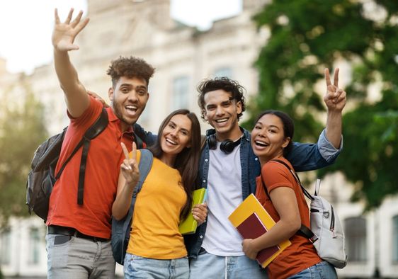 A group of college friends smile.
