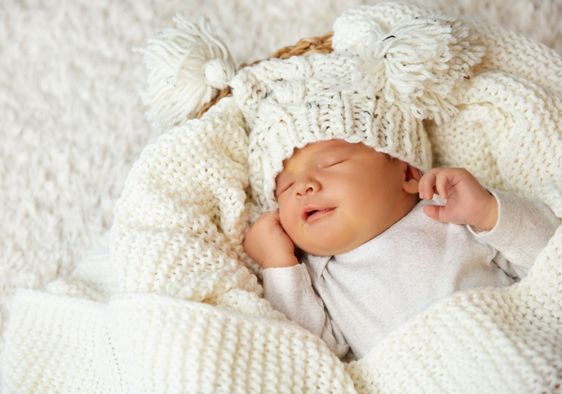 A baby smiles while sleeping.
