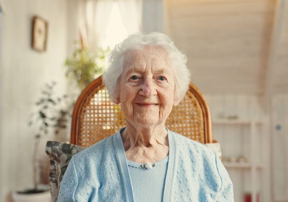 An elderly woman smiles.
