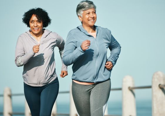 Senior women running on a boardwalk.