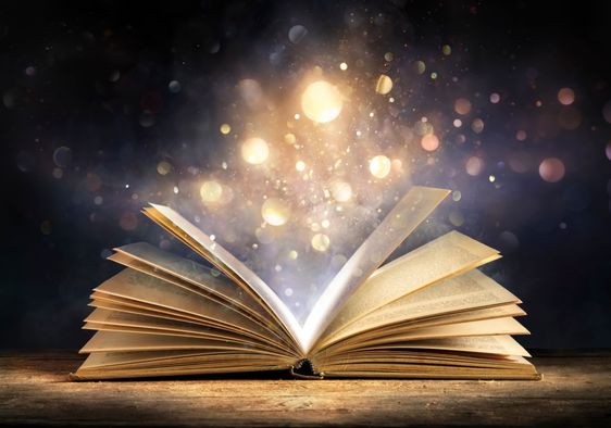 An open antique book softly glows with warm golden light.