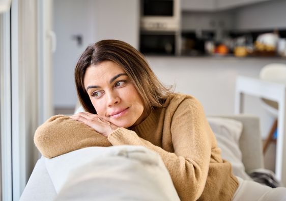 A woman sits on a sofa.