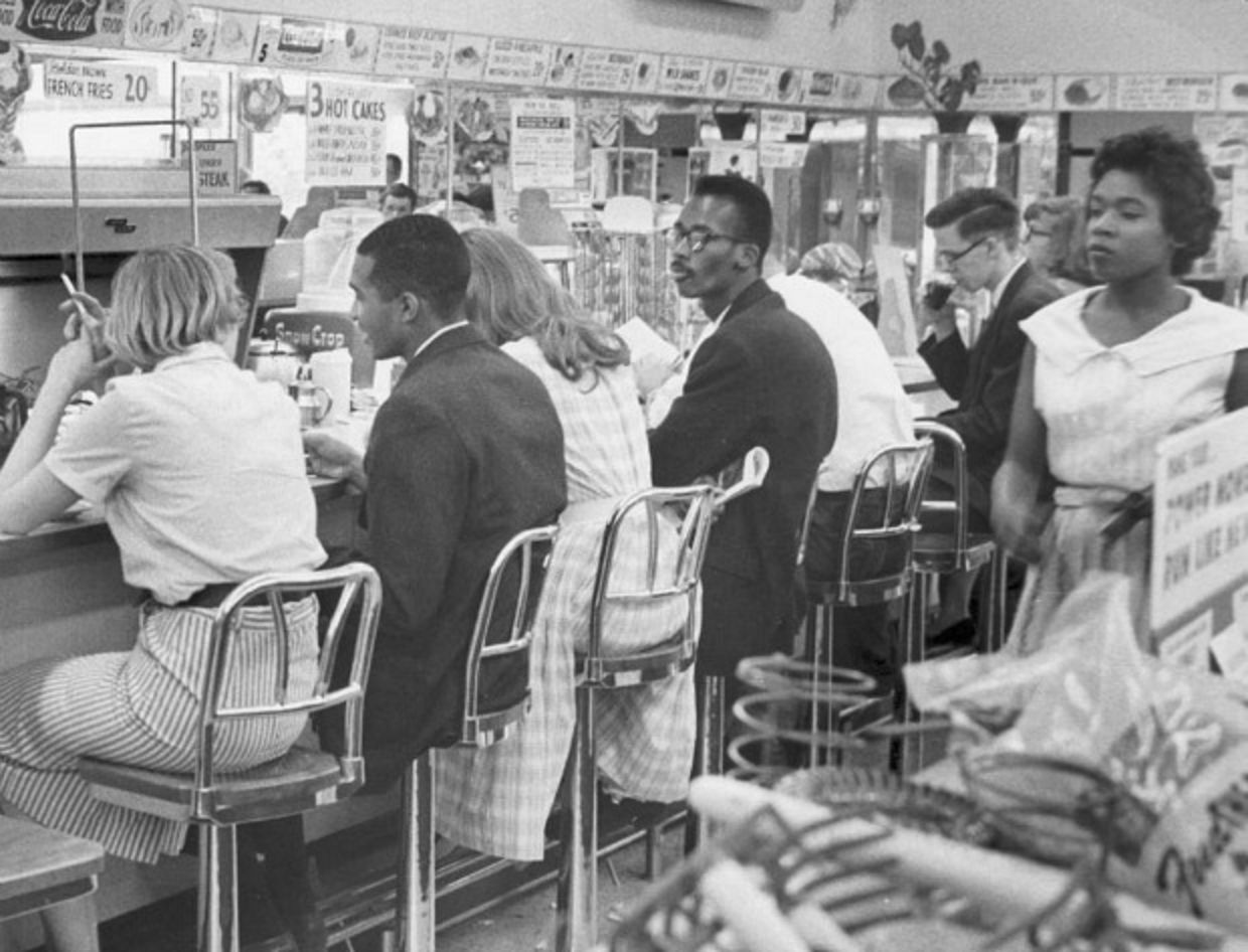Blacks and whites sitting at lunch counter during 1960's sit-ins