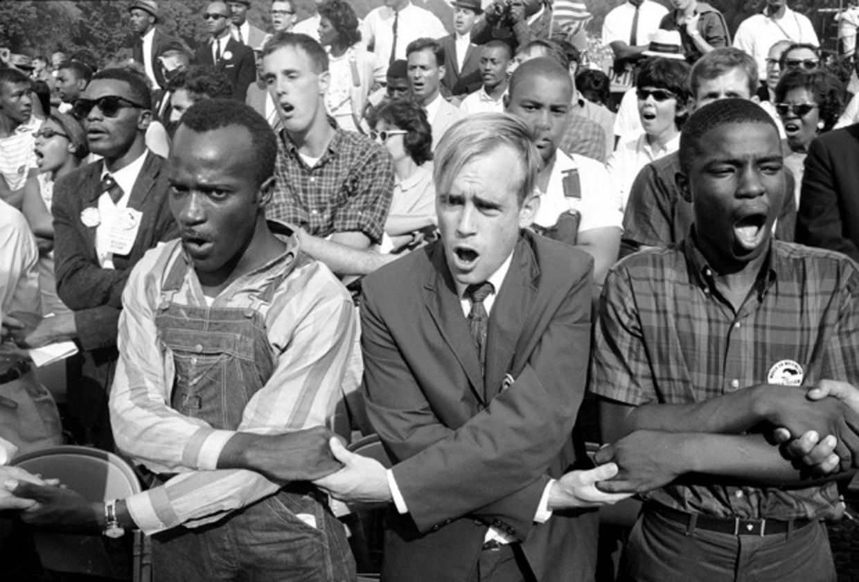 Blacks and white holding hands during civil rights rally