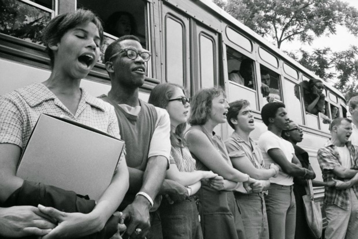 Blacks and white standing outside bus preparing for freedom ride