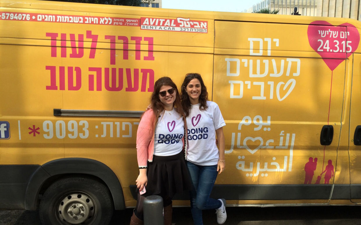 Volunteers pose next to the Good Deeds Day Truck in Tel Aviv, Israel