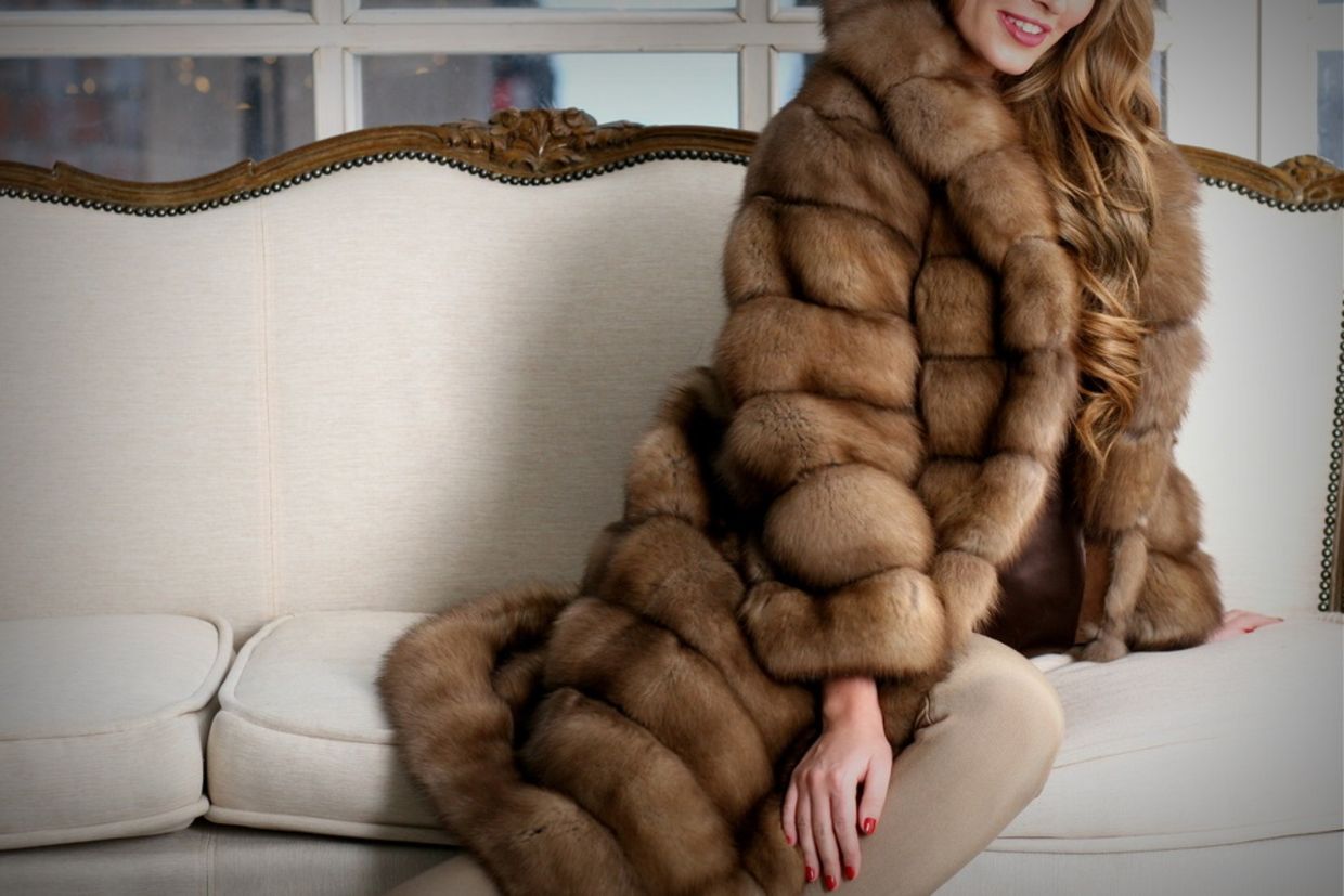 Woman in fur coat, close up, on the sofa, fur texture