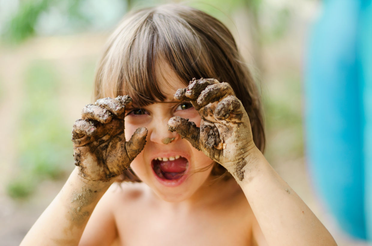 child with muddy hands