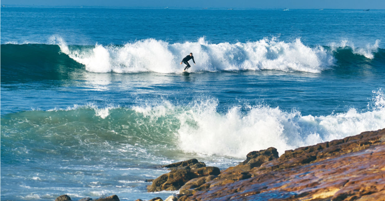 Young man surfing at Dracula's, Morocco