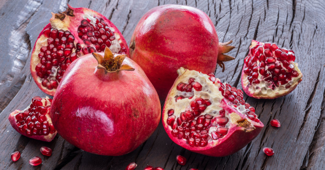 Ripe pomegranate fruit on wooden vintage background.