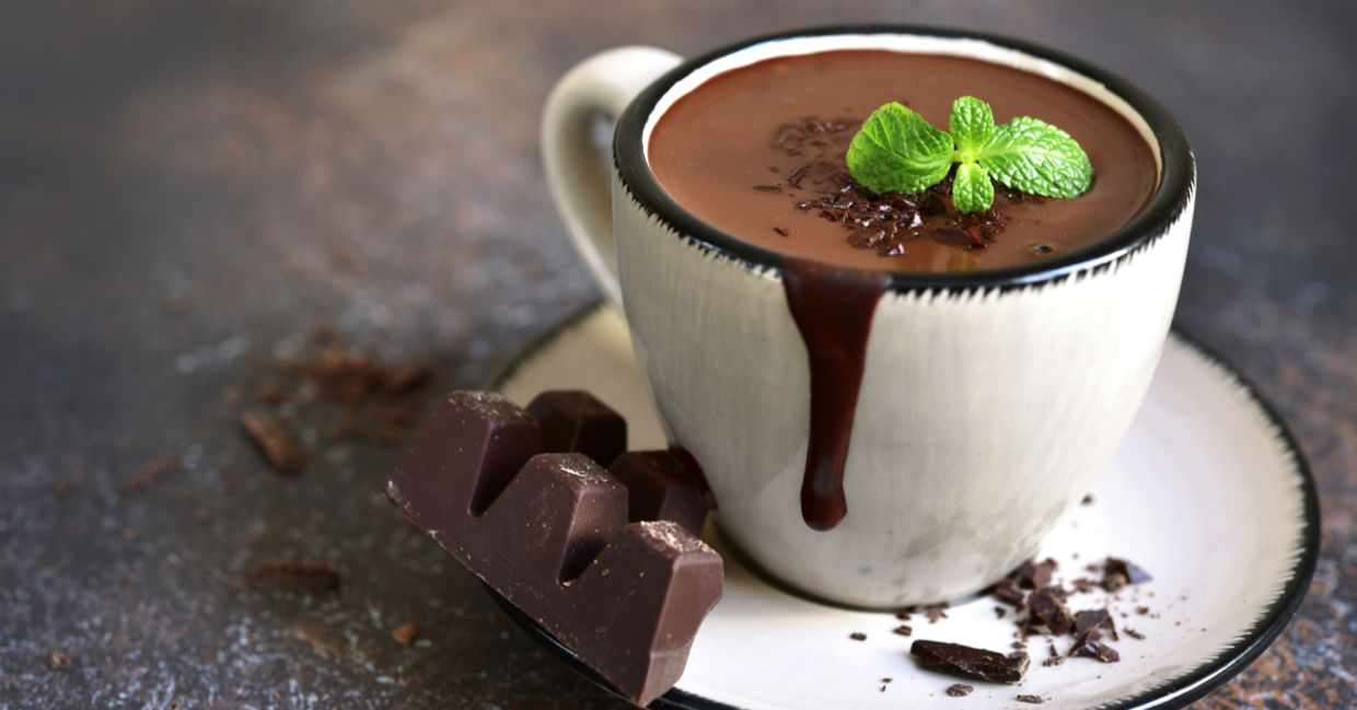 A delicious mug of peppermint hot cocoa topped is with a refreshing mint leaf.