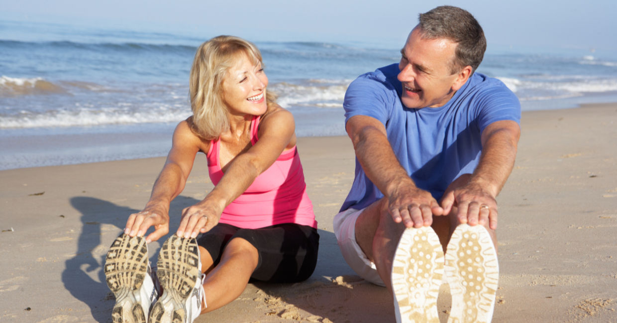 A couple stretching on the beach may have reduced hypertension.