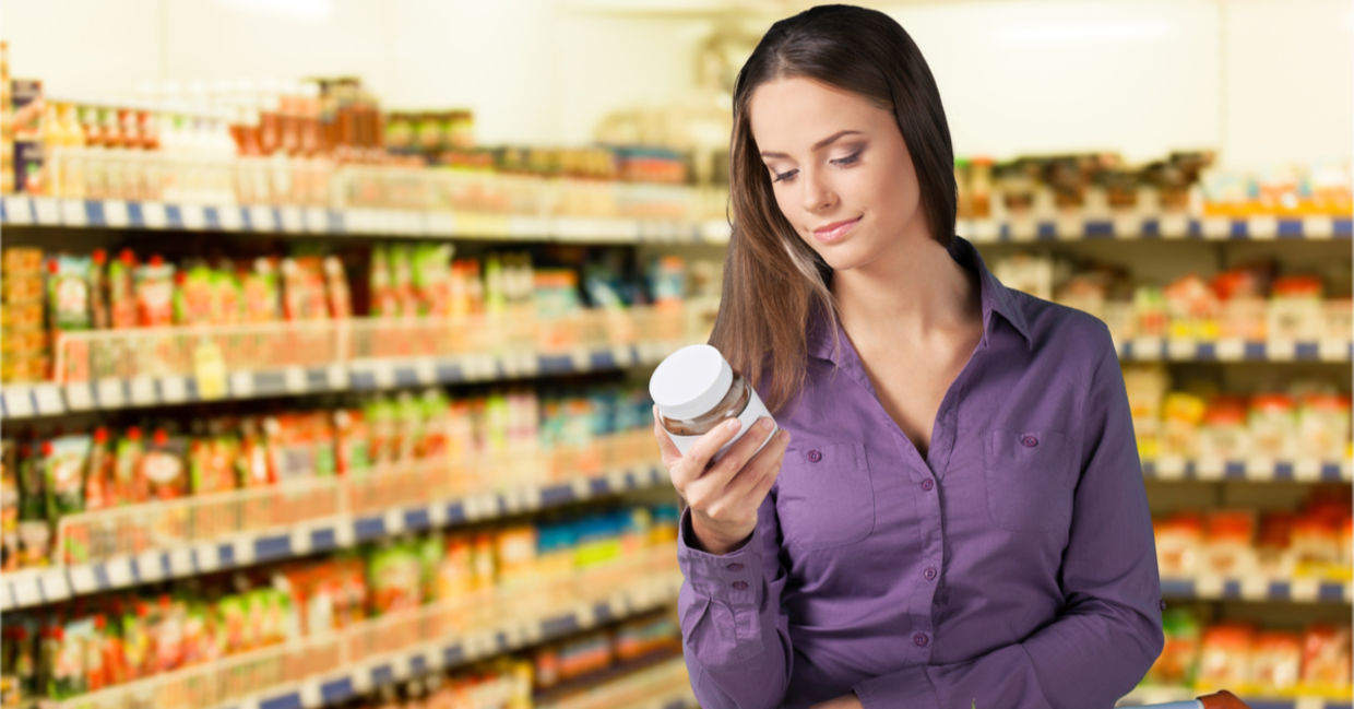 Woman reading food label in supermarket