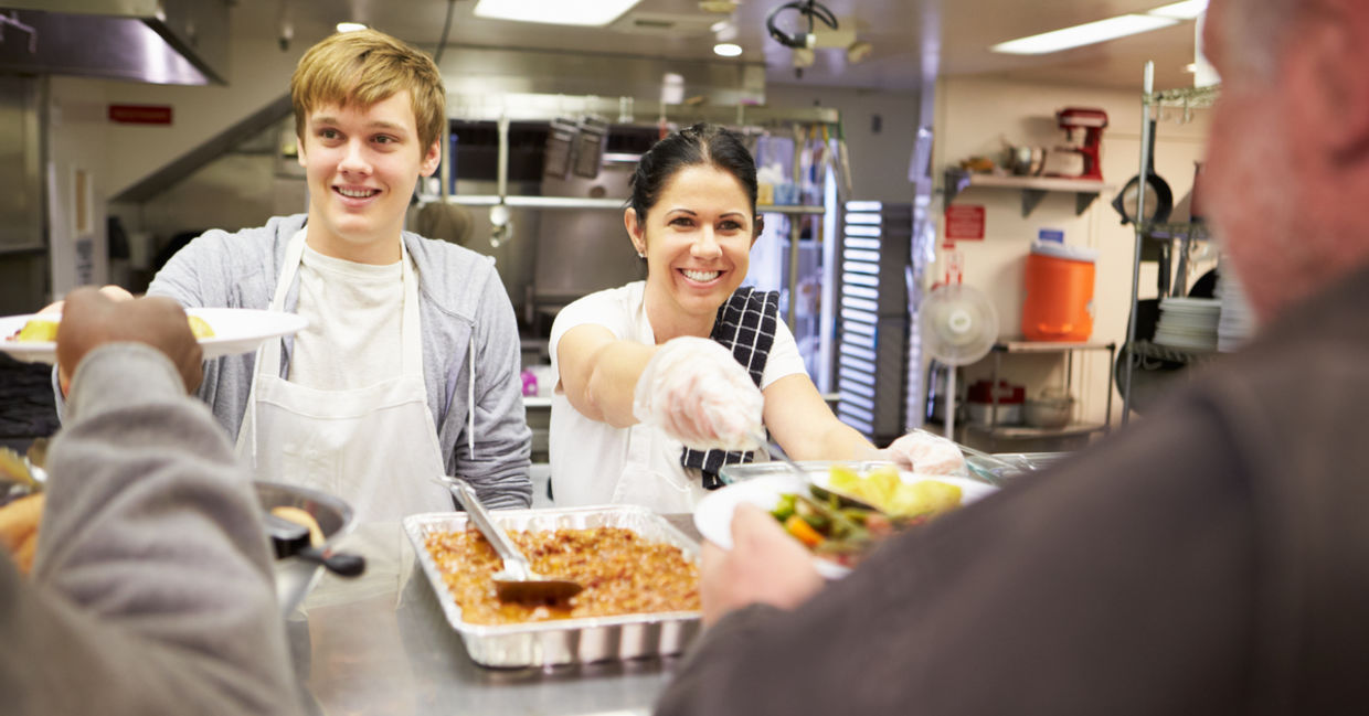 Two volunteers serving dinner