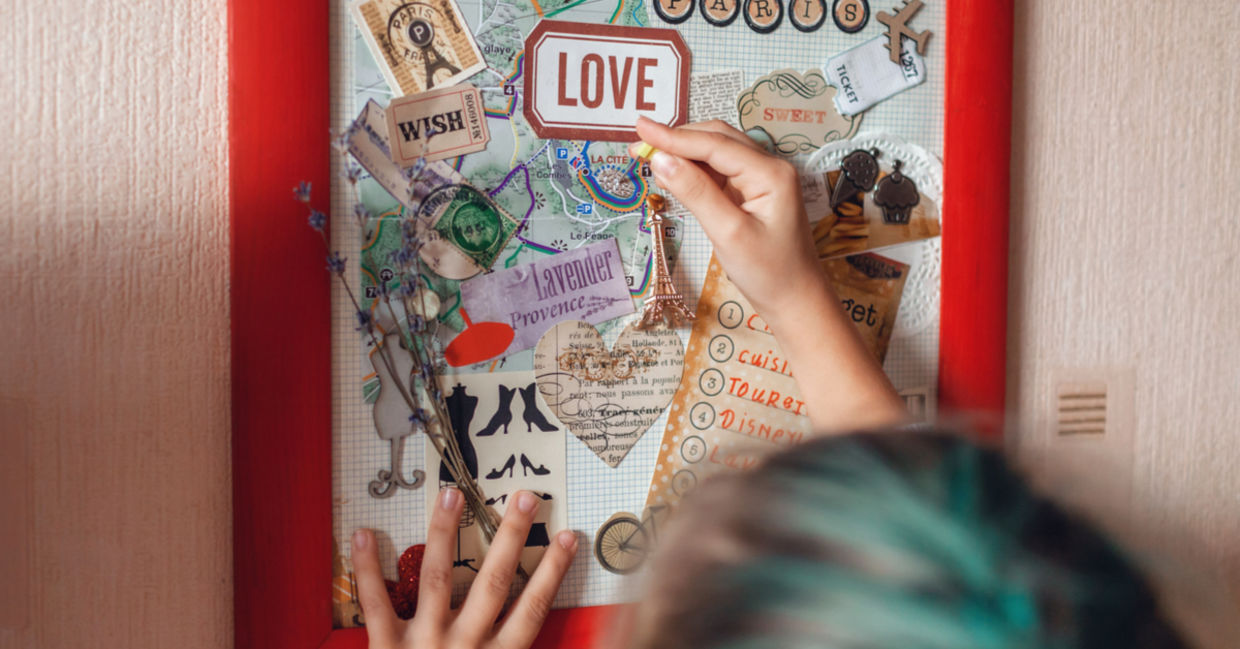A vision board idea for travel to France is made by a woman who wants to manifest travel.