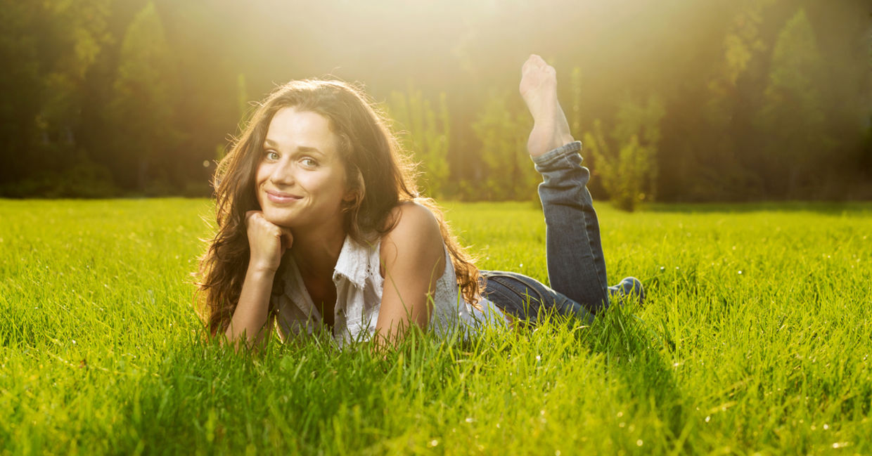 Happy woman laying on grass