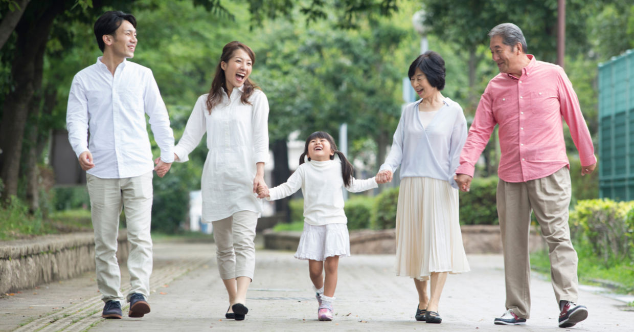 A Japanese family stays connected, enjoying a walk in the park.