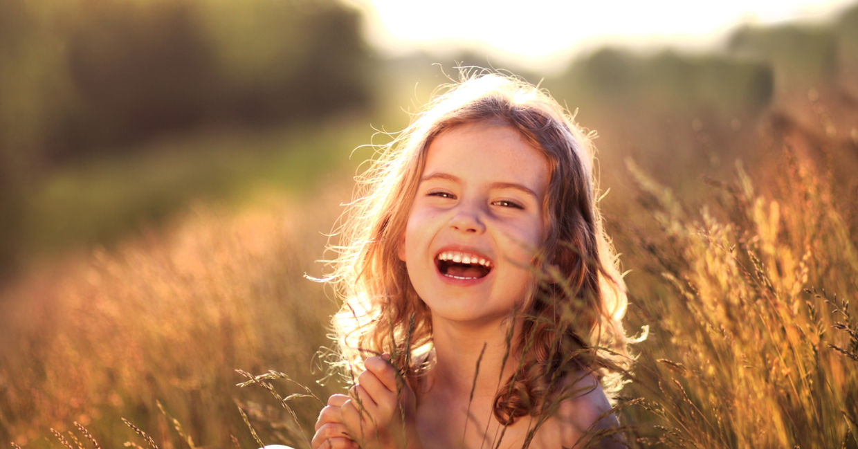 Girl laughing in meadow