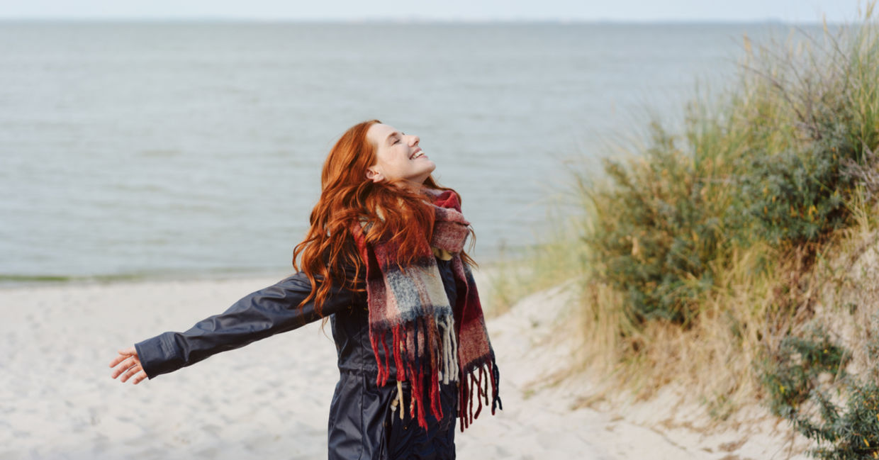 Joyful woman flings arms out