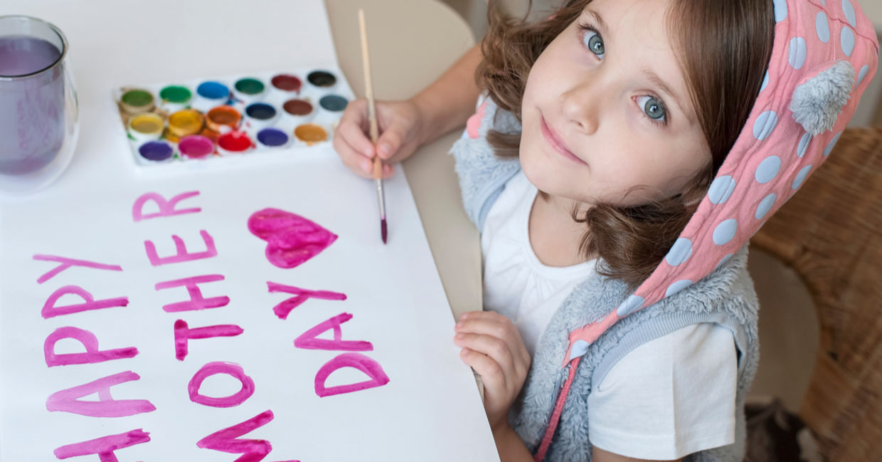 A young girl paints a Mother’s Day card.