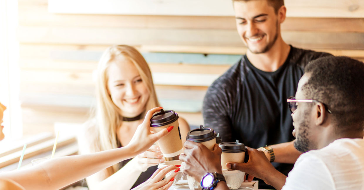 Colleagues sitting and meeting with coffee cups in their hands.