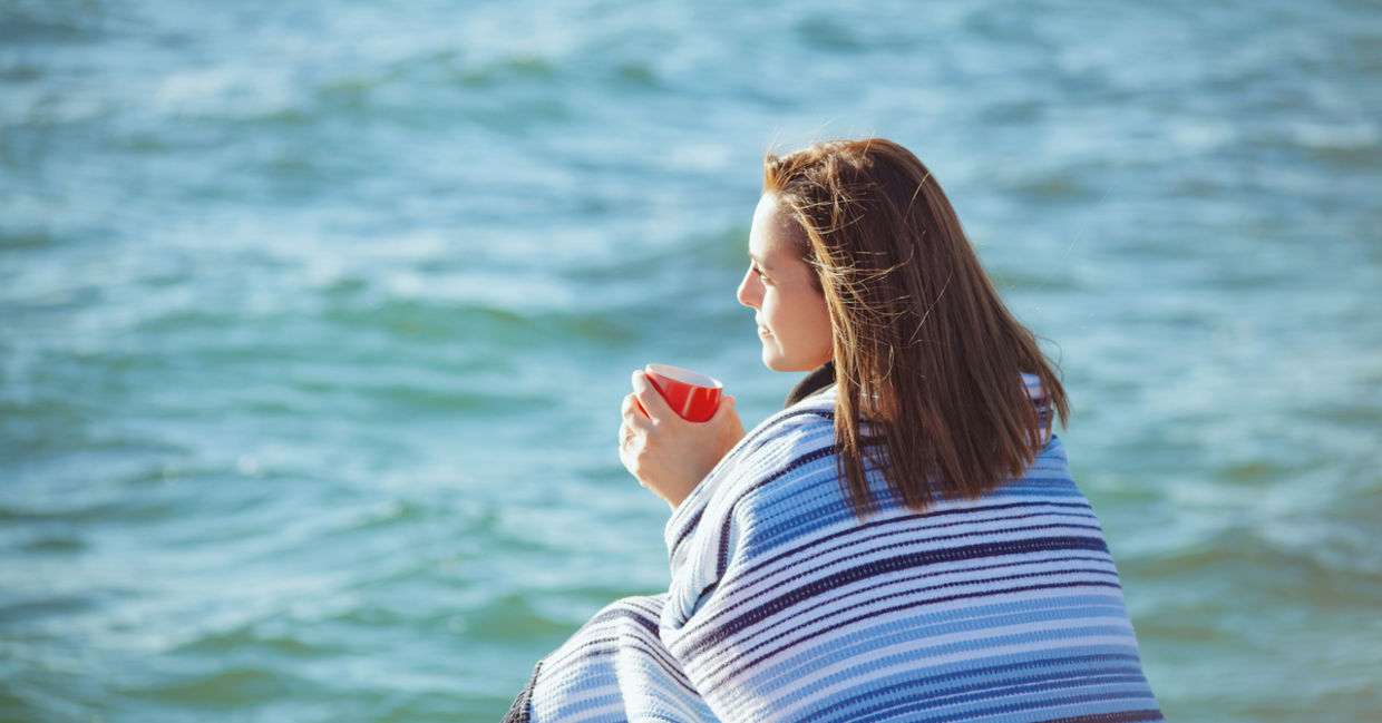 Woman sitting by the sea to manage stress