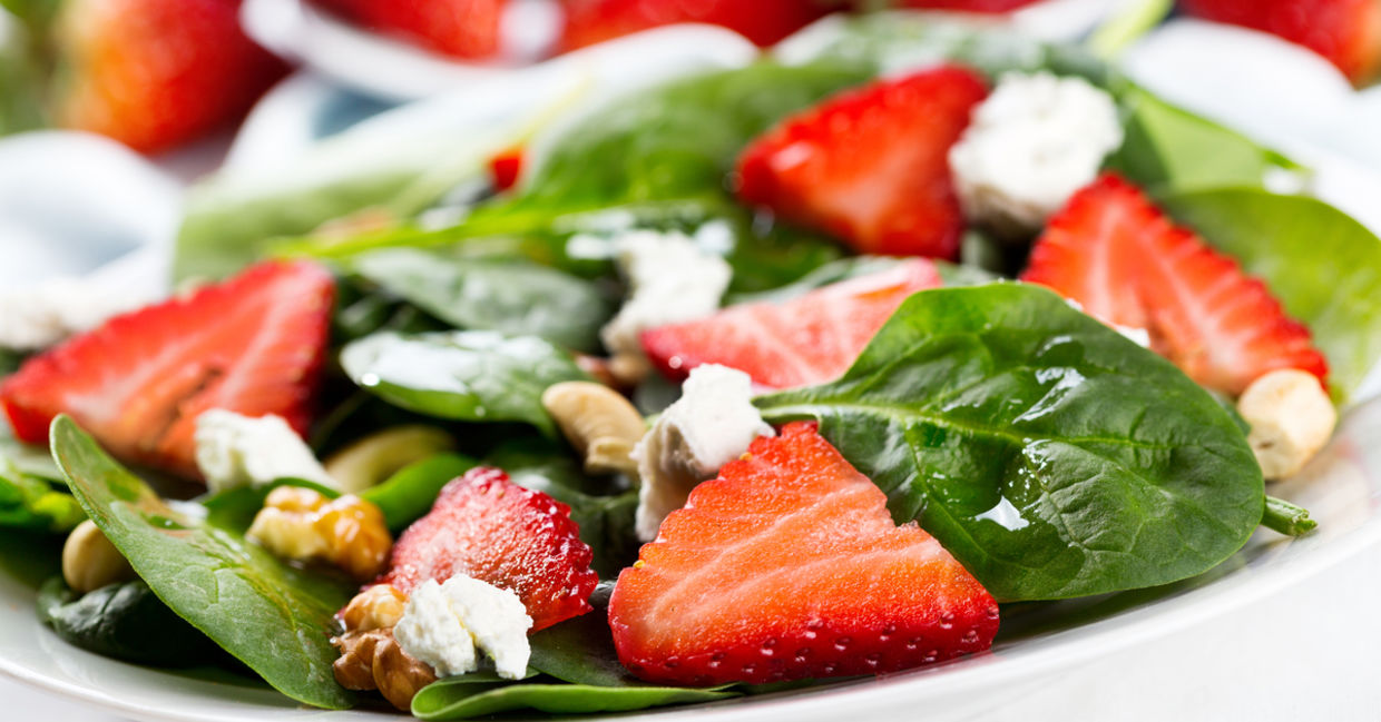 A healthy green salad with strawberries.