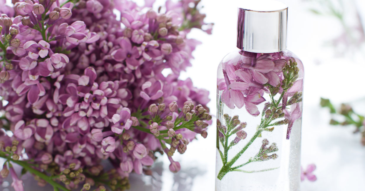 Bottle of spray with lilac flowers.