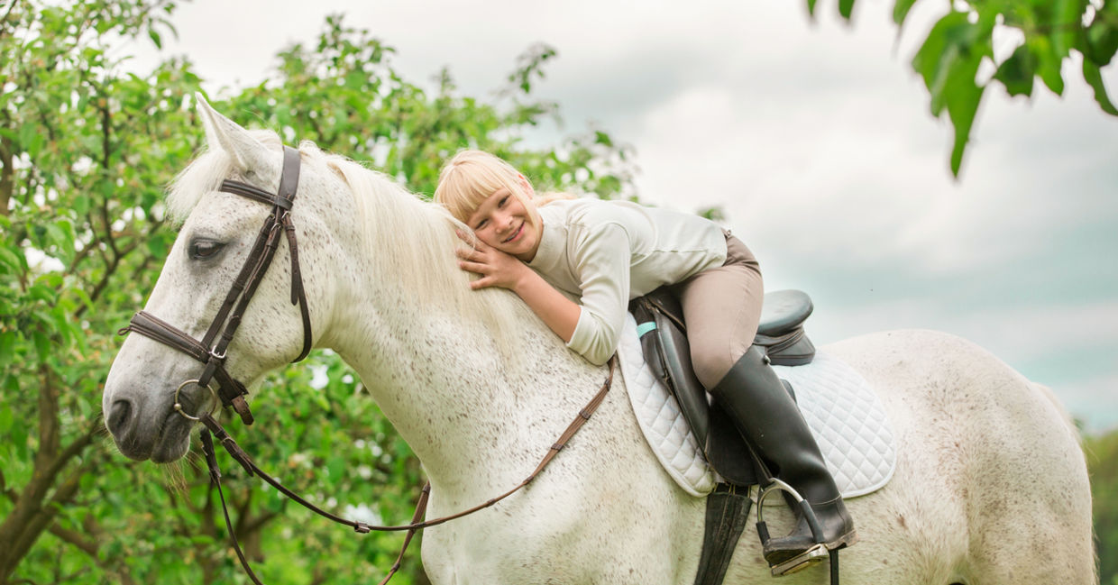 Girl getting pet therapy with a horse.