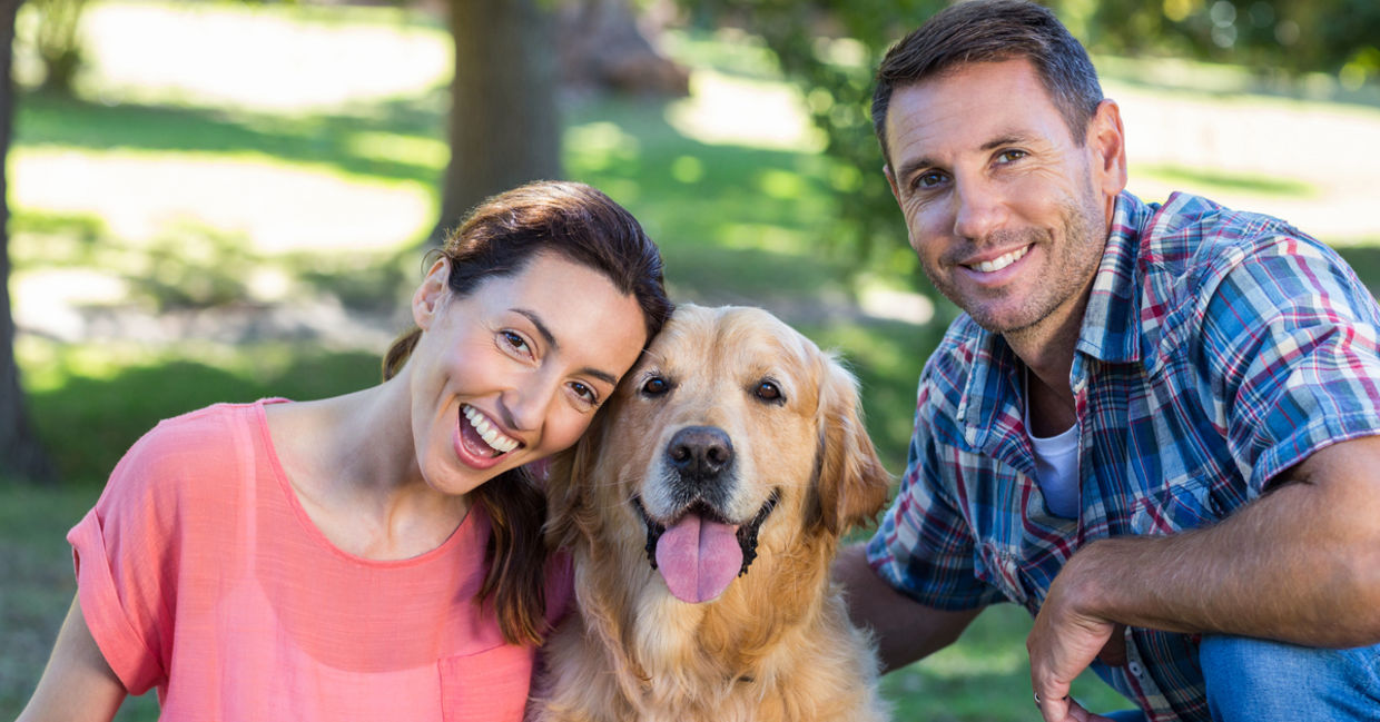 Happy couple with their dog in the park