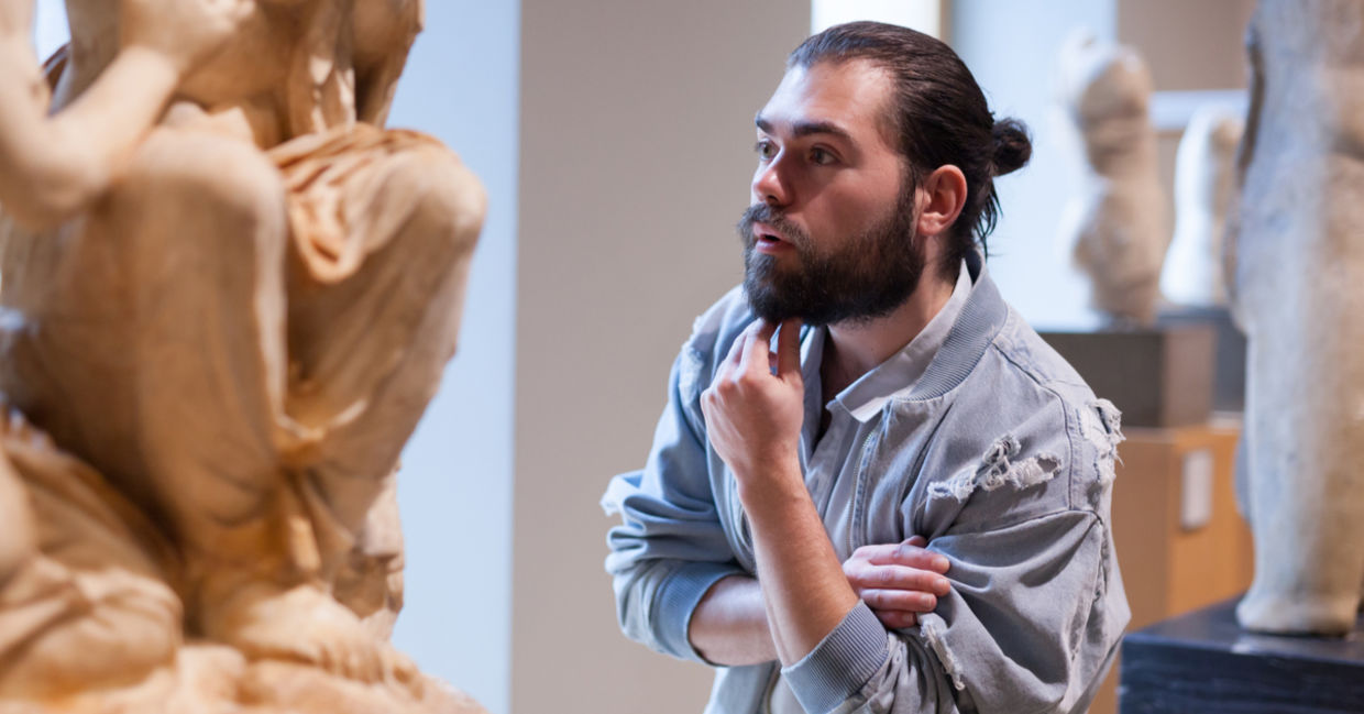 Man explores a sculpture in a museum.