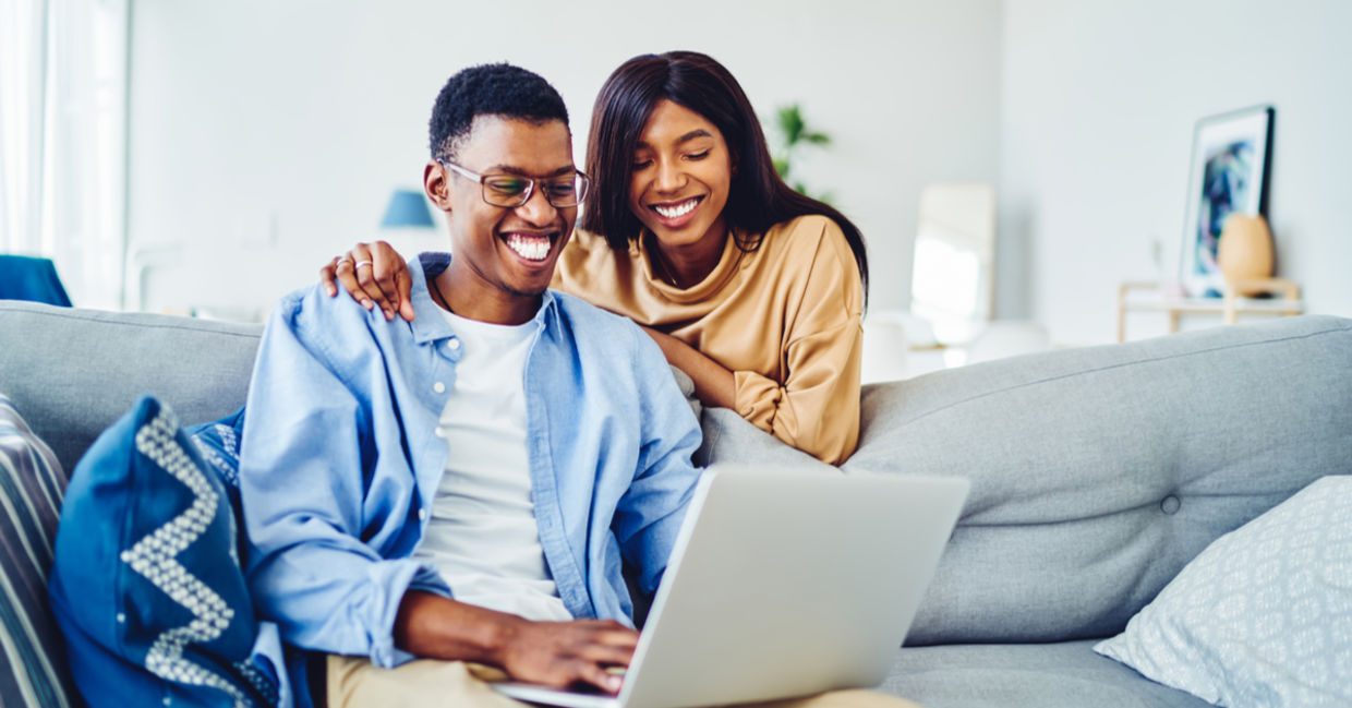 A couple looking at a website on their computer.