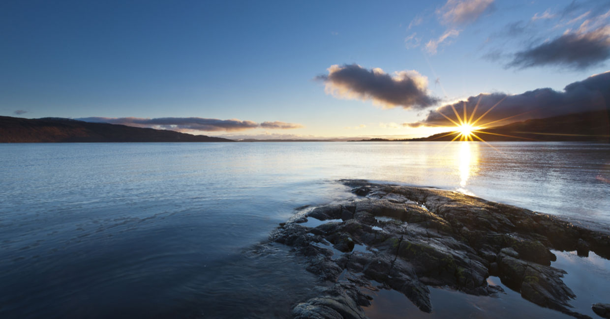 Beautiful sunset over a rocky lake in Scotland promotes spirituality.