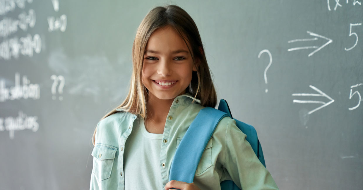 Smiling schoolgirl poses in her classroom