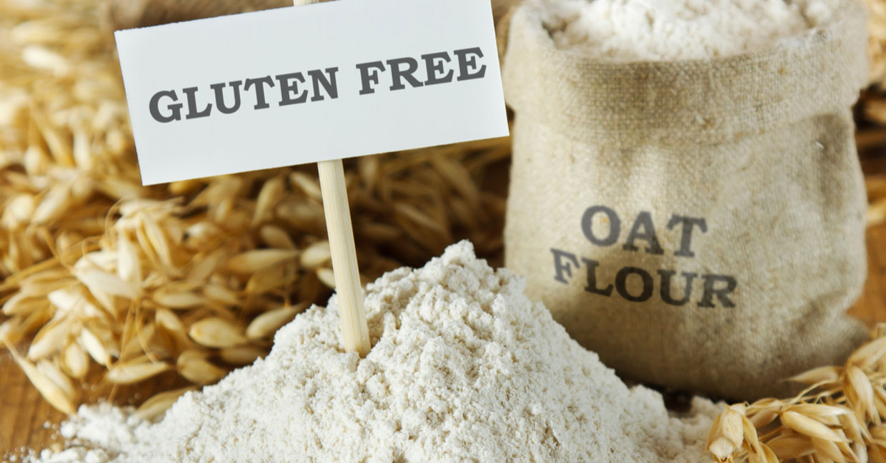 Raw oats, plus a bag of oat flour set beside a sign that reads gluten free.
