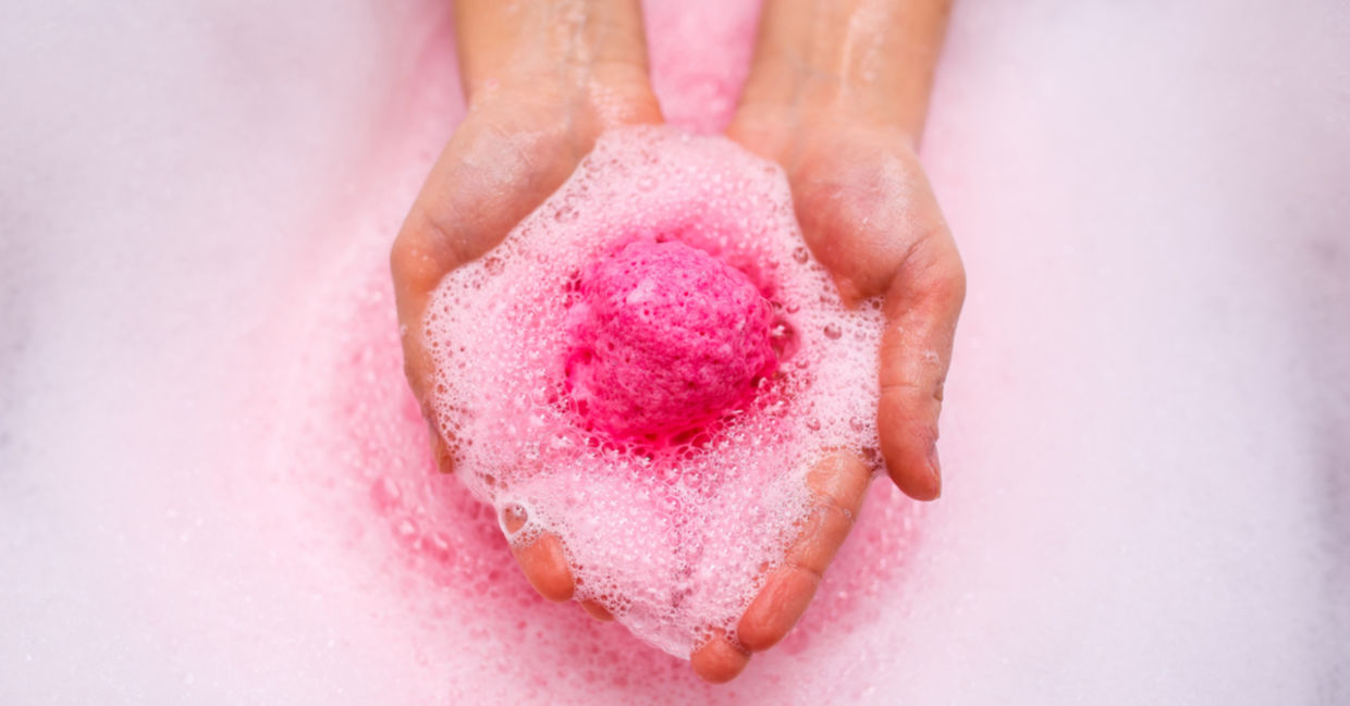 A pink shower steamer dissolves in a woman’s hands.