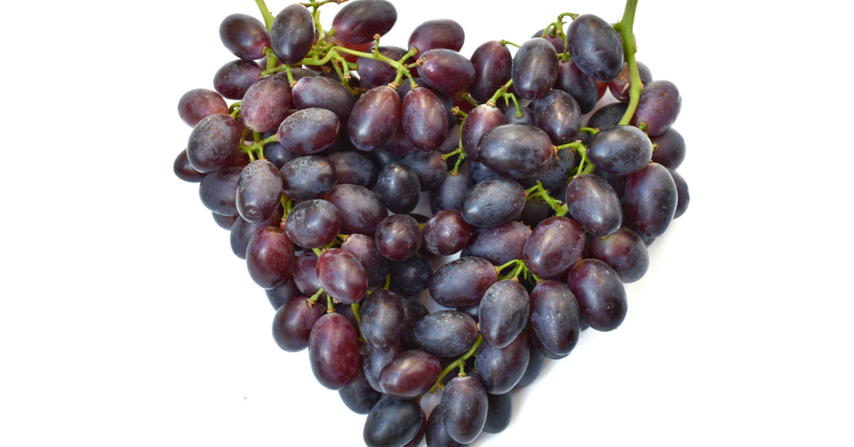 Bunches of purple grapes in the shape of a heart.