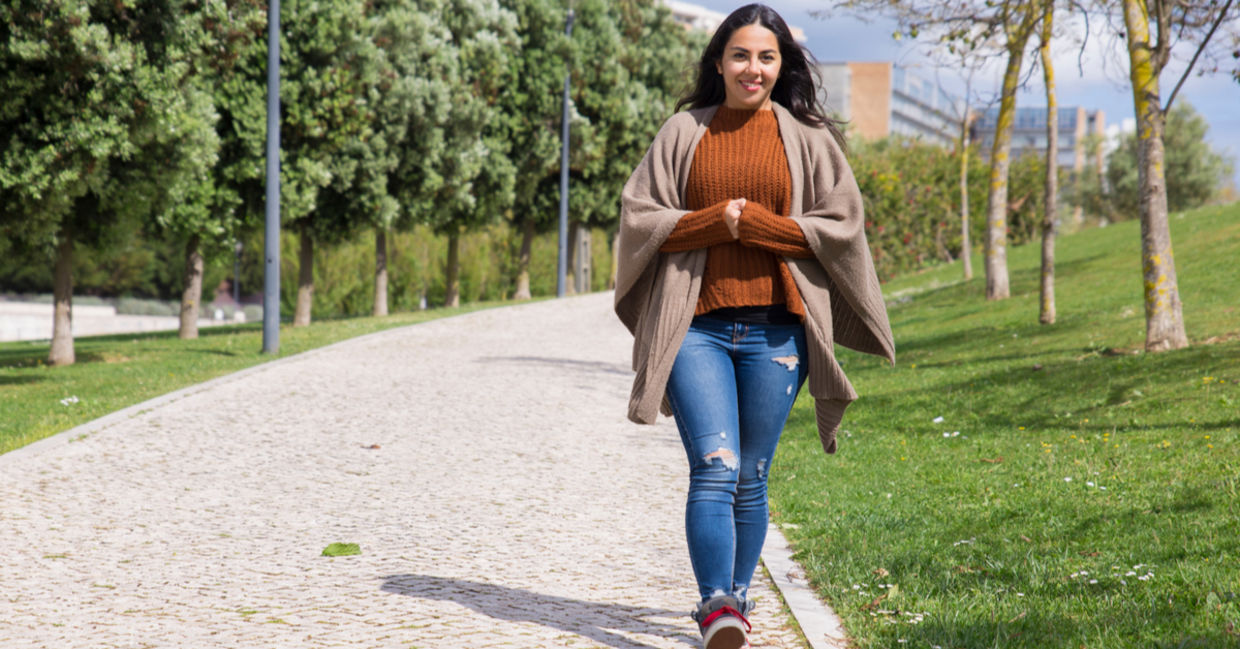 Smiling young woman taking a walk in the park.