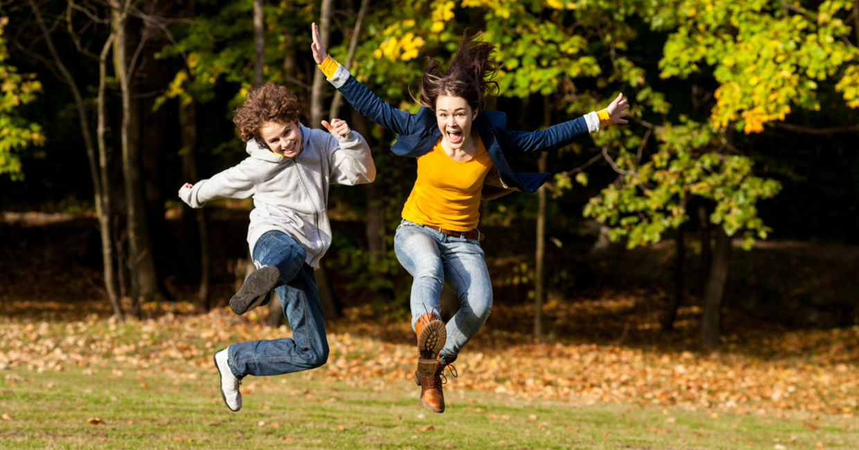 Girl and boy jumping and enjoying the outdoors.