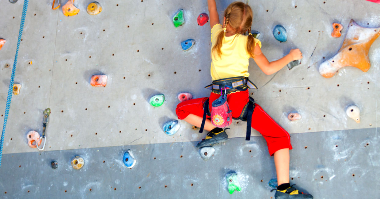 Girl climbing a rock indoor wall.