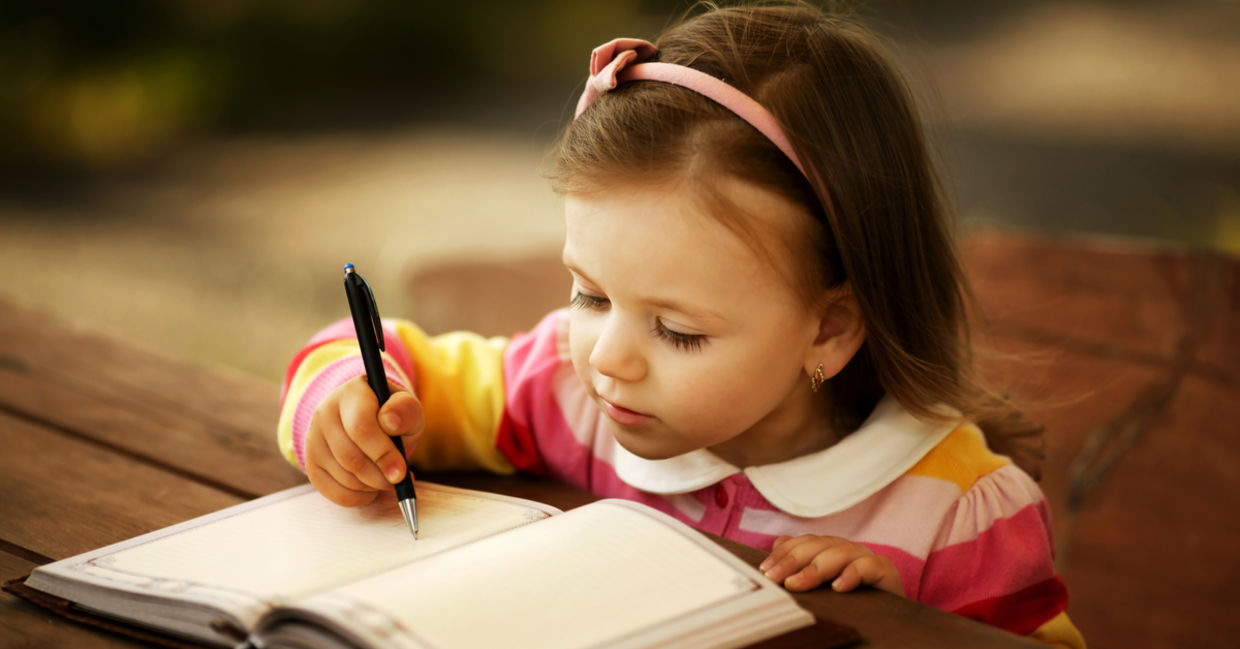 A little girl learning to write.