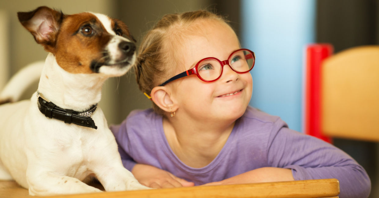 Cute girl learning with the help of a friendly dog.