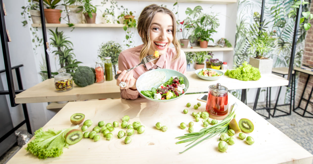 A woman eats healthy food including brussels sprouts.