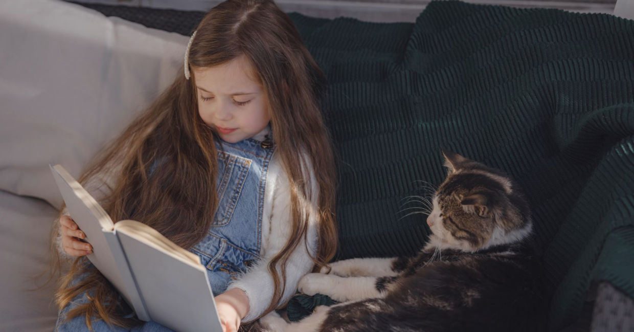Young girl reading to her pet.