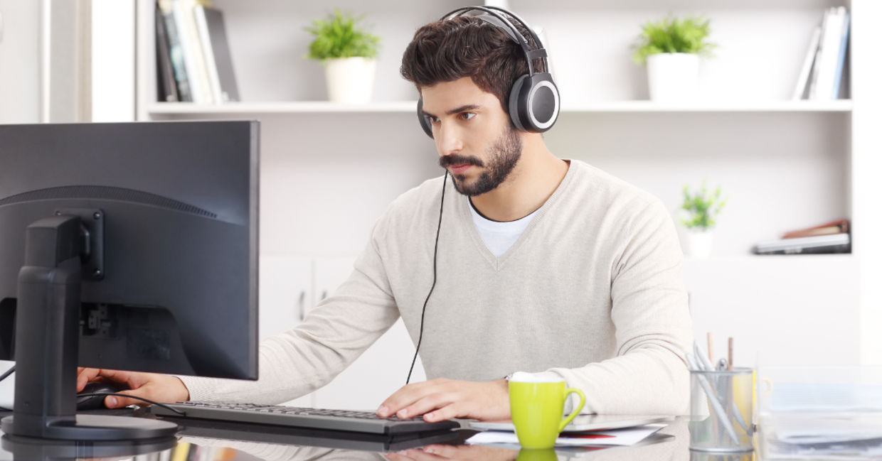 A young man sitting with headphones.