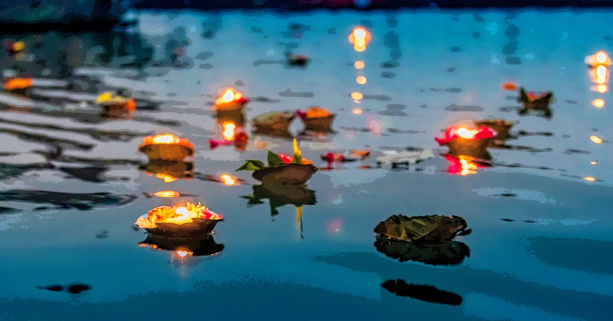 Light and flower spiritual offerings in the Ganges River.