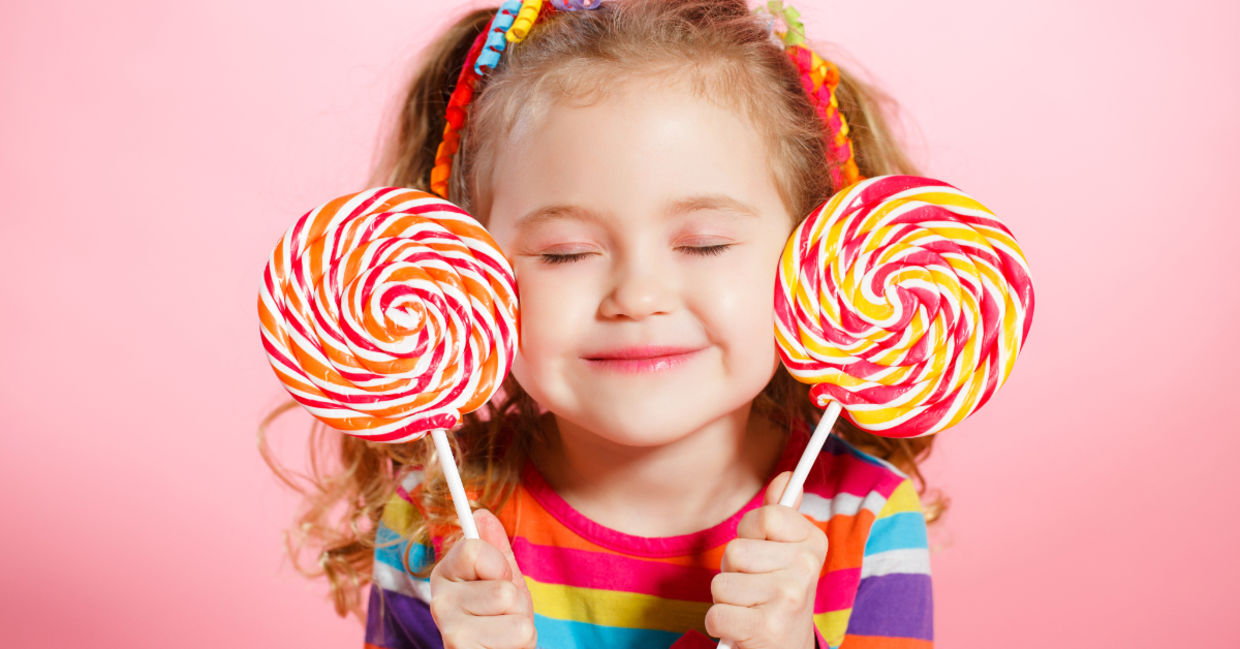 Happy child with candy lollipops.