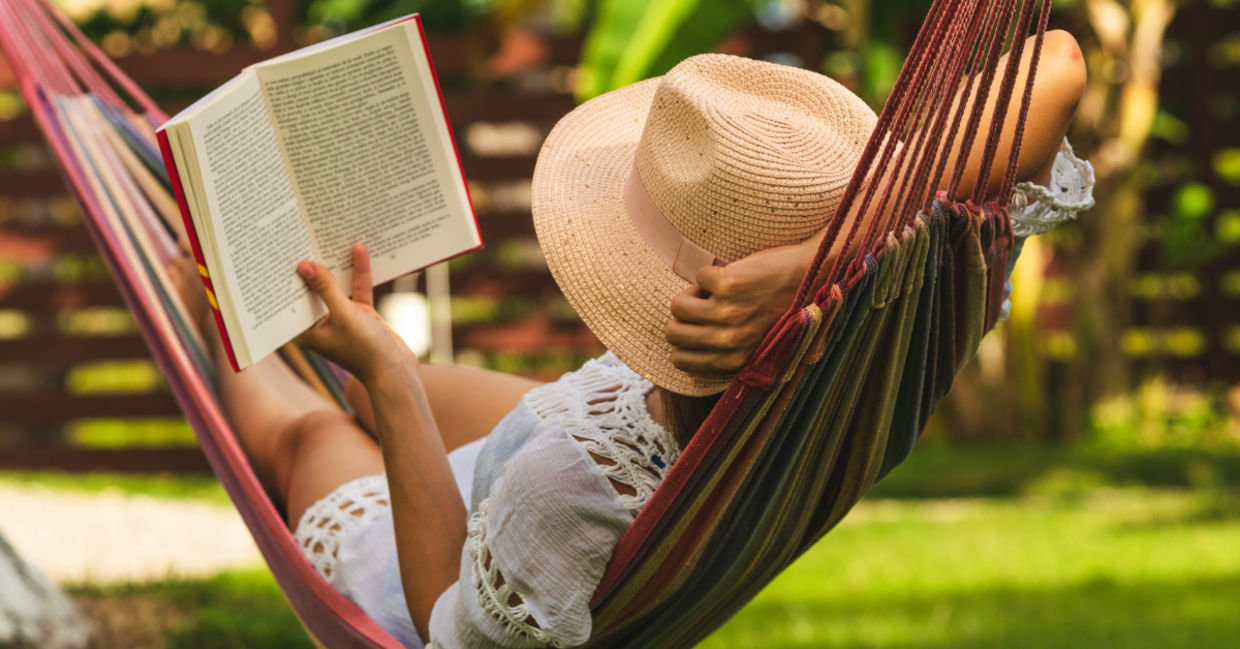 Woman in a hammock reading a book.